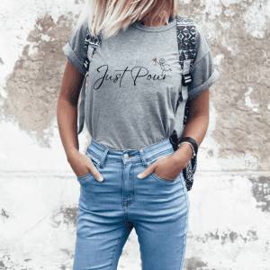 Blonde female wearing a grey statement shirt Just Pour