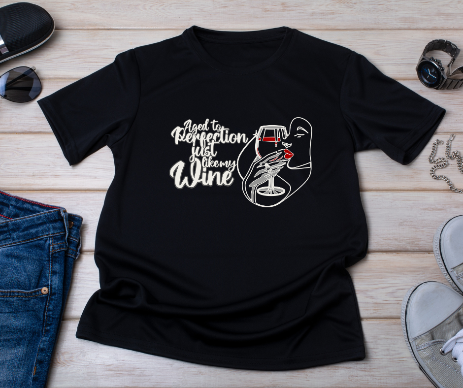 Black t-shirt on displayed on a wooden background with the graphic aged to perfection just like my wine
